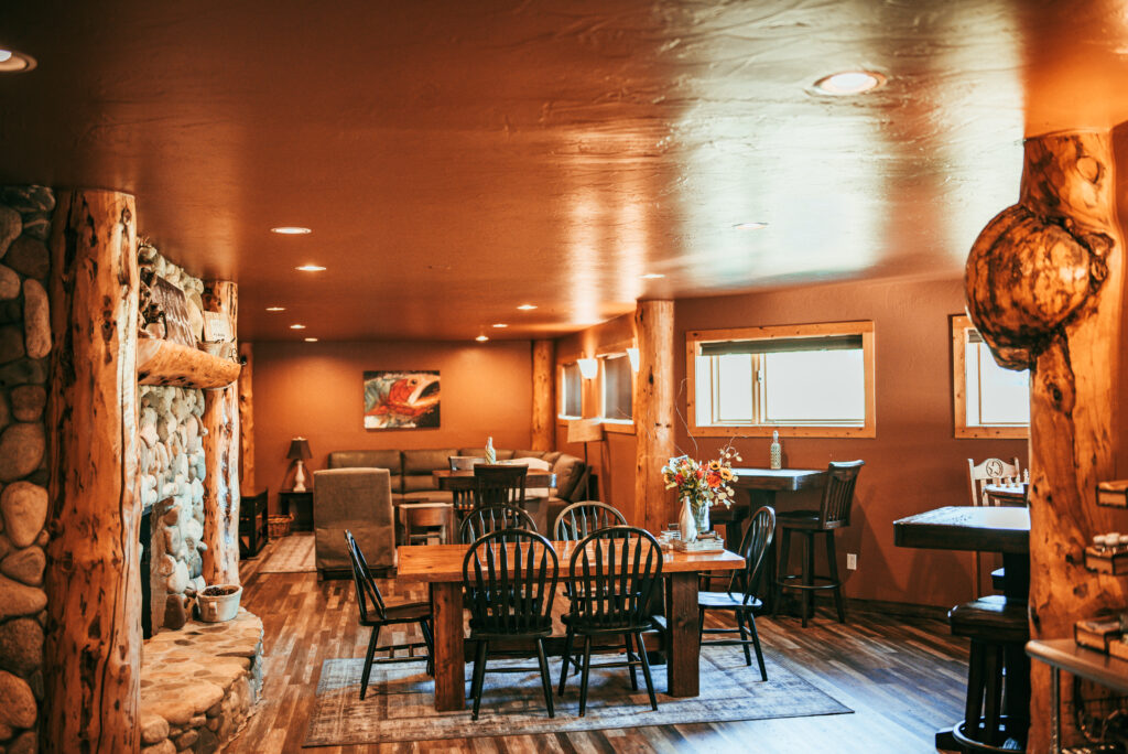 Lodge dining room with stone fireplace and log pillars