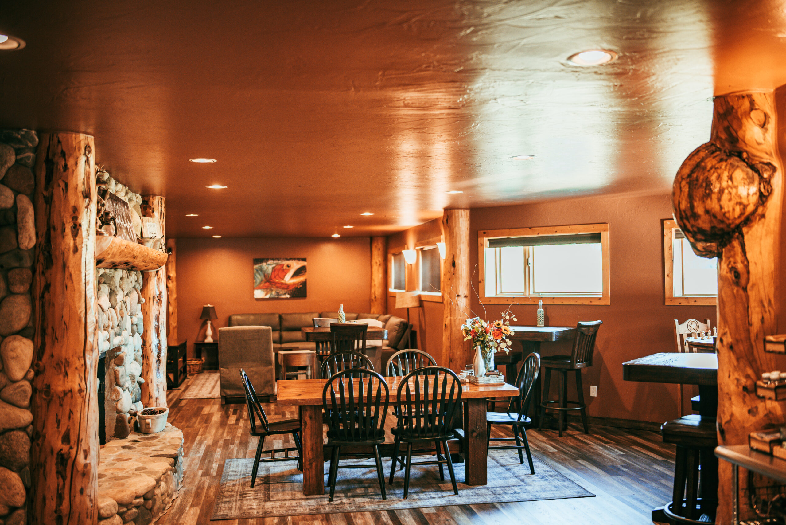 Lodge dining room with stone fireplace and log pillars