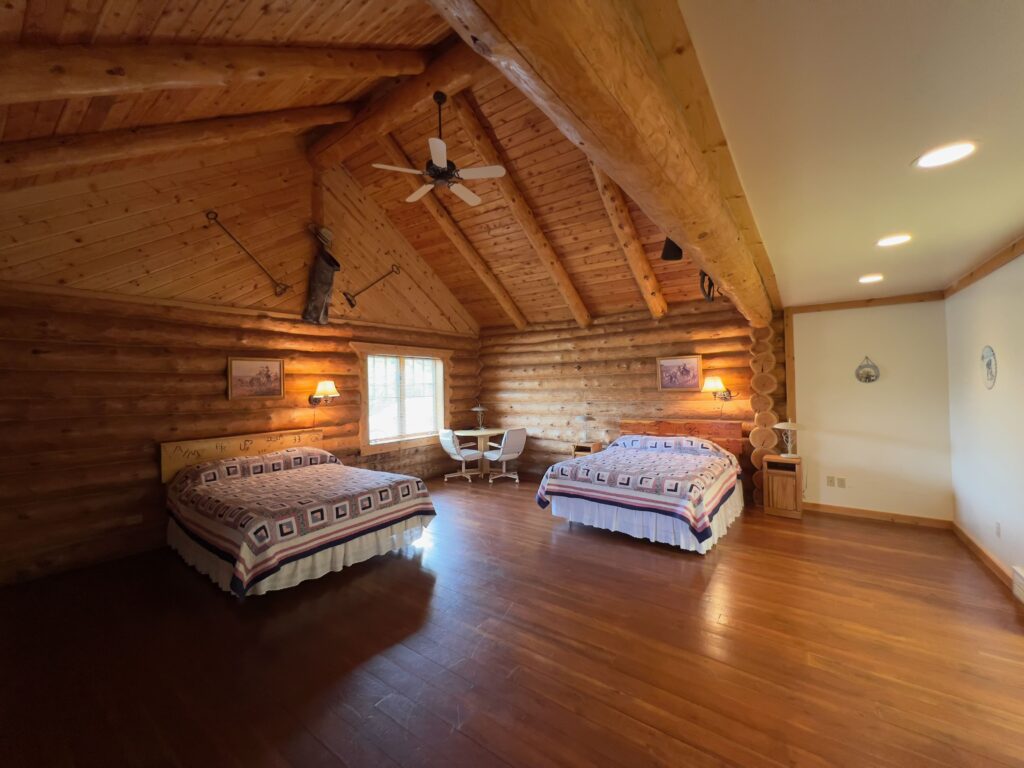 Spacious log cabin bedroom with vaulted ceiling and lodge furnishings
