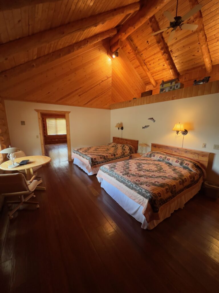Double queen guest room with log construction and lodge furnishings
