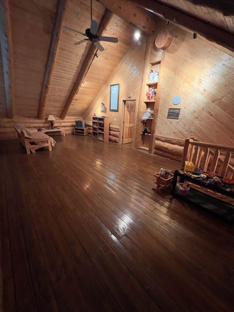 Loft media room with lodge seating and log construction