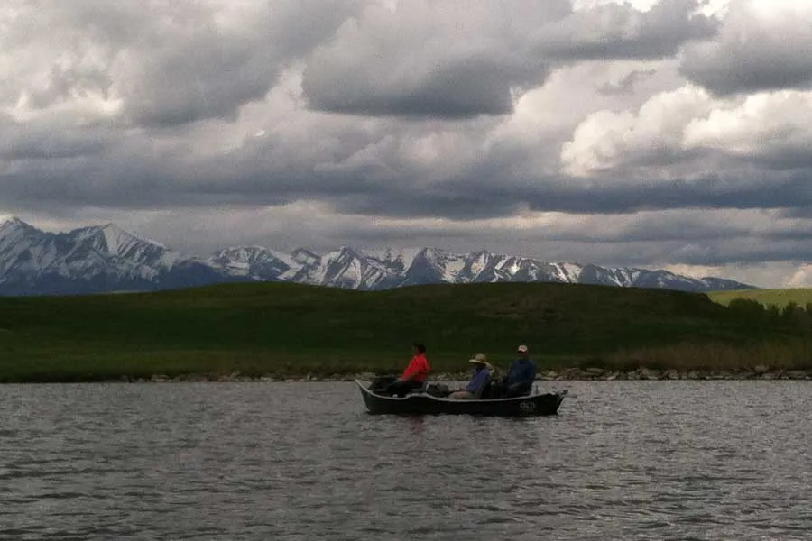 Drift boat on Burns Lake with Crazy Mountains behind