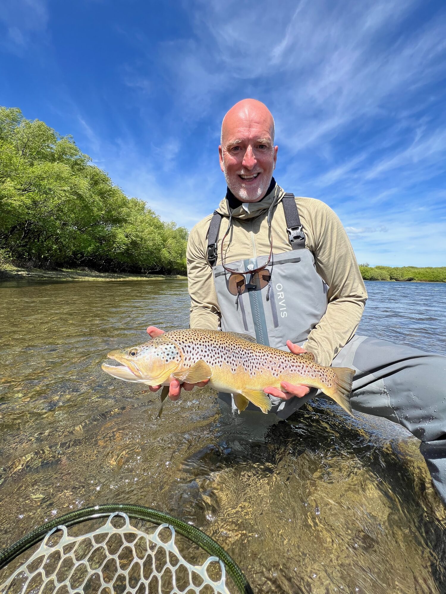 Lincoln Powers holding a wild brown trout on the river