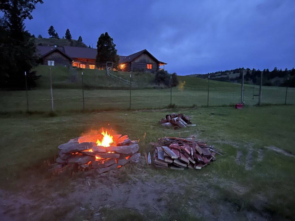 Fire pit at dusk with the lodge glowing in the background