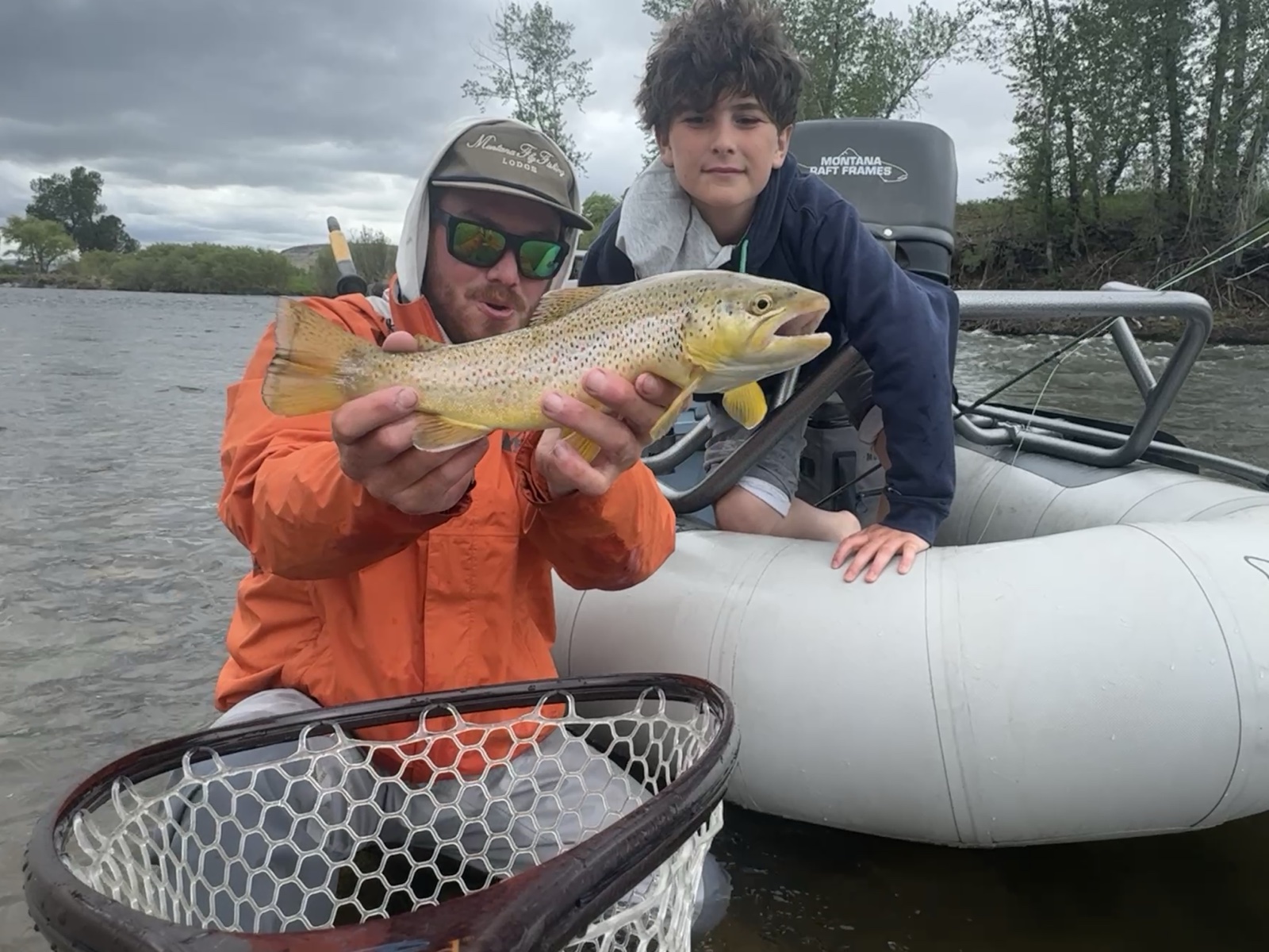 Guide Sean McLendon instructing a young guest with a brown trout