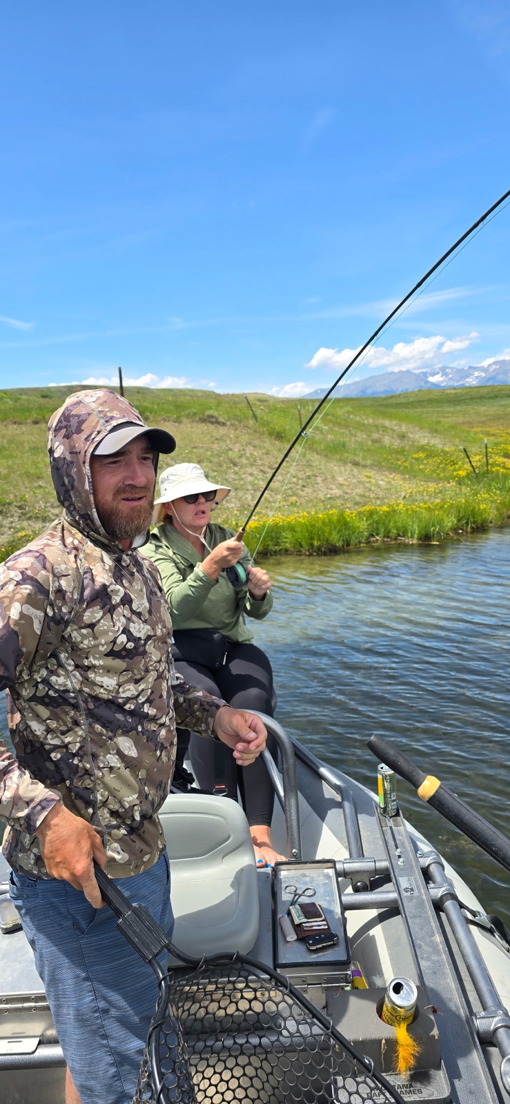 Guide Neal Mitchell working a bent fly rod with a guest on a spring creek